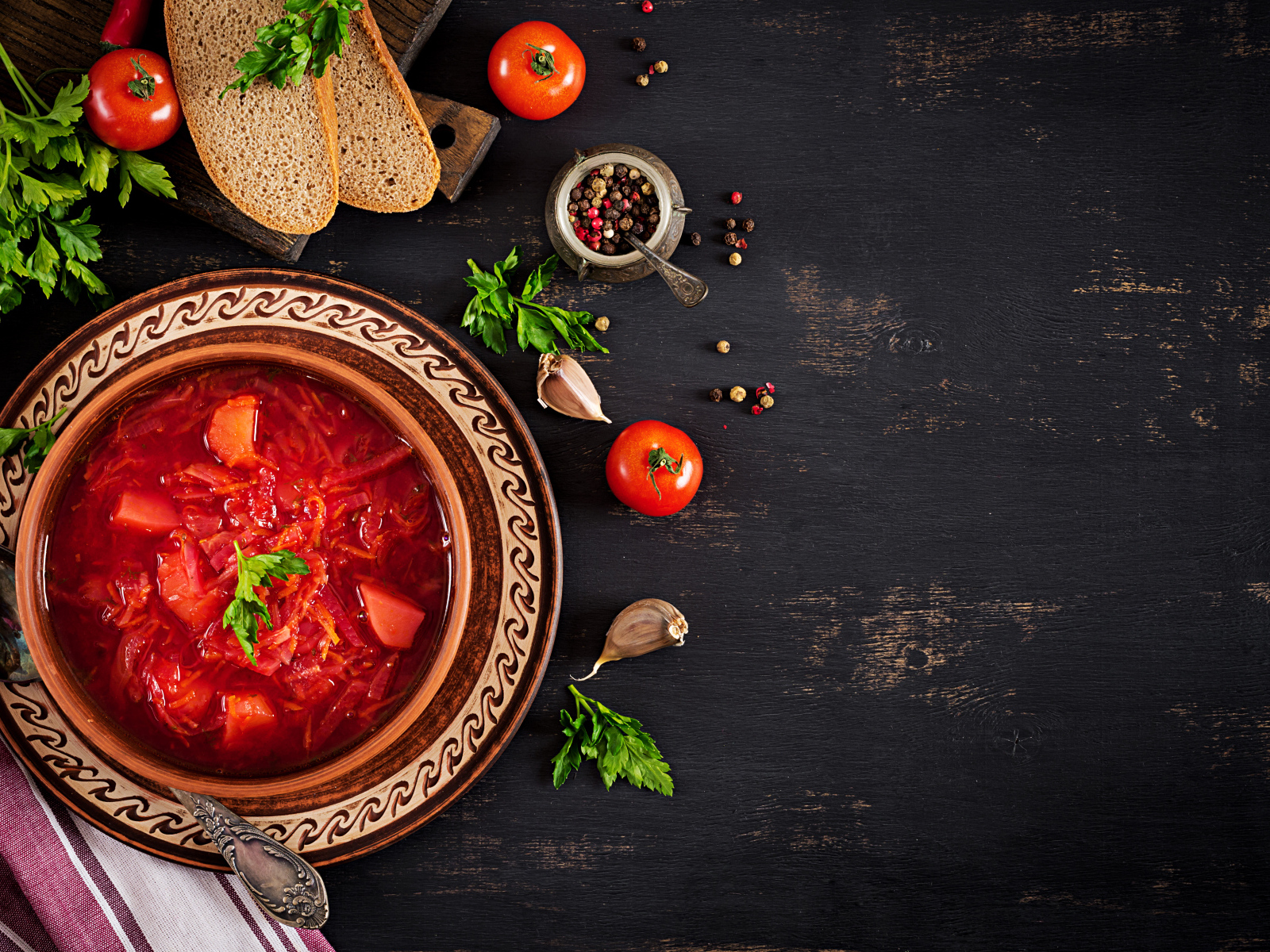 Вкусный красный борщ в тарелке на столе