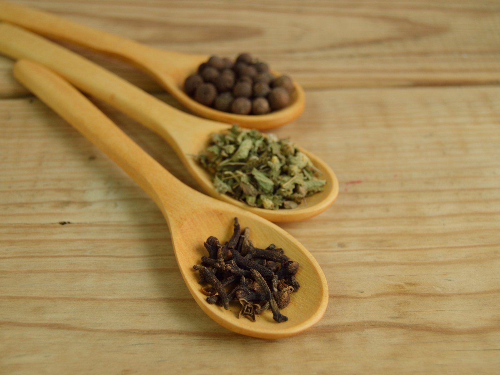 Three wooden spoons with spices