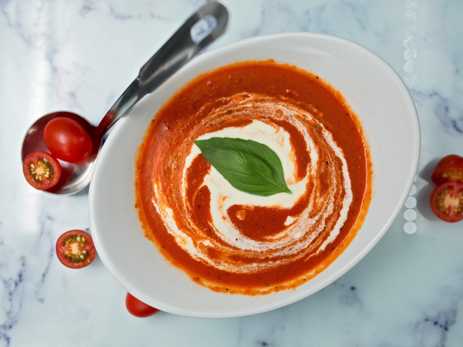 Томатный суп со сметаной в белой тарелке
