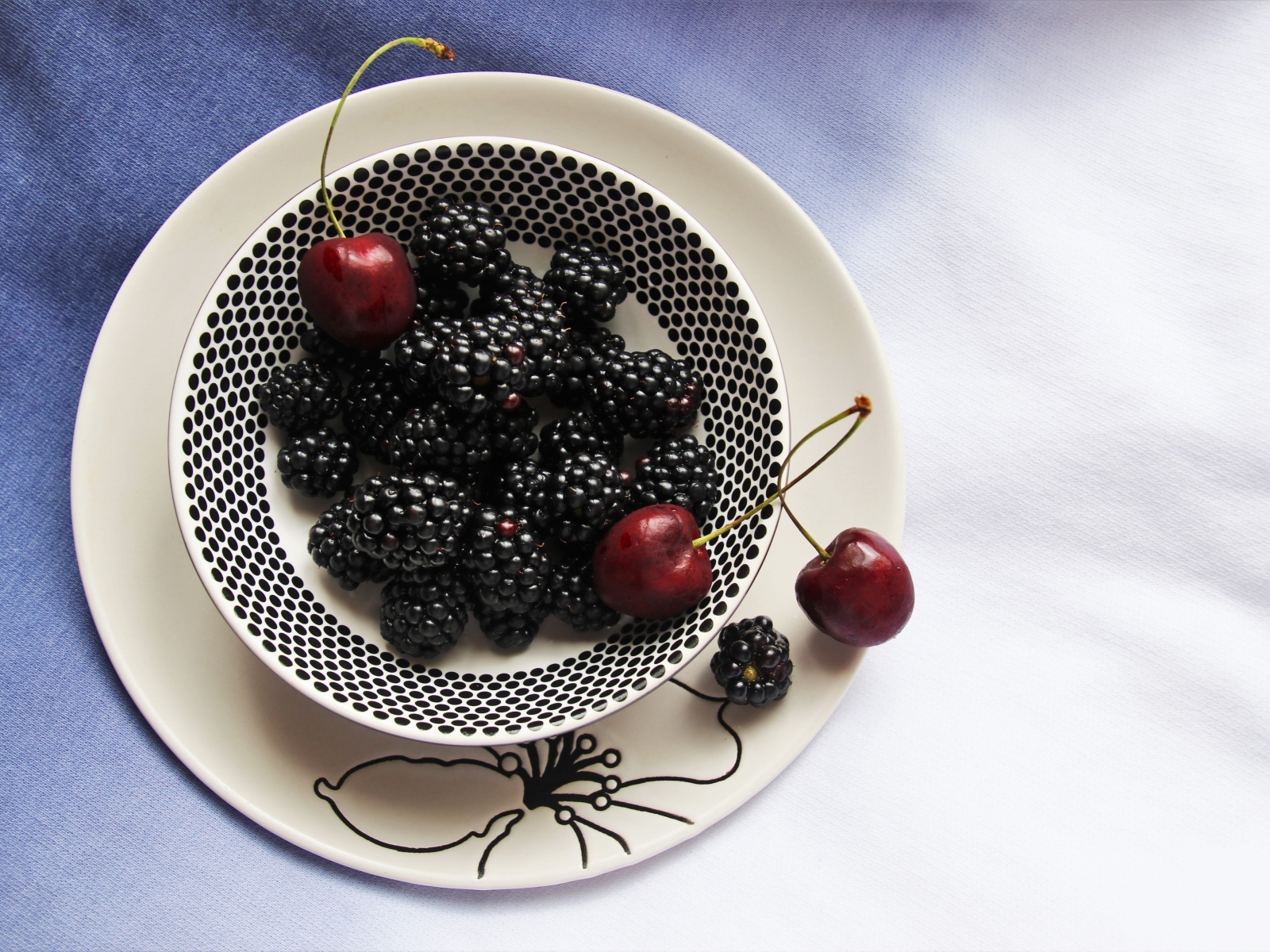 Ягоды ежевики и черешни на столе