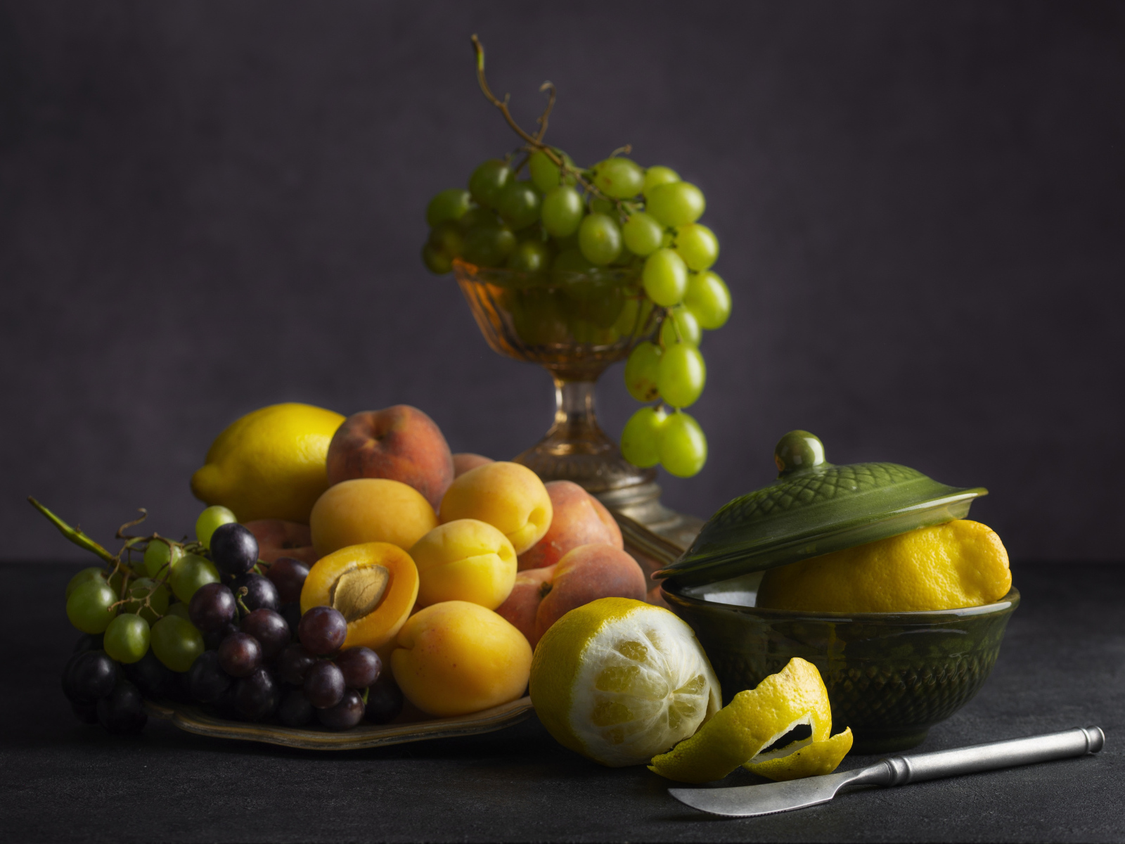 Свежие фрукты и ягоды на столе с ножом