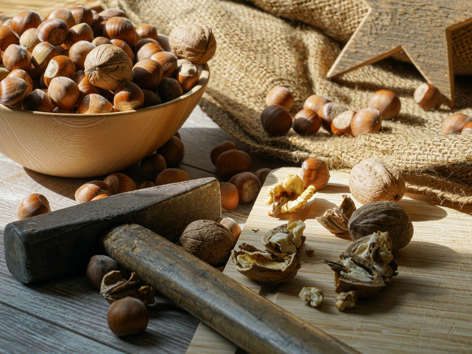 Фундук и грецкие орехи на столе с молотком