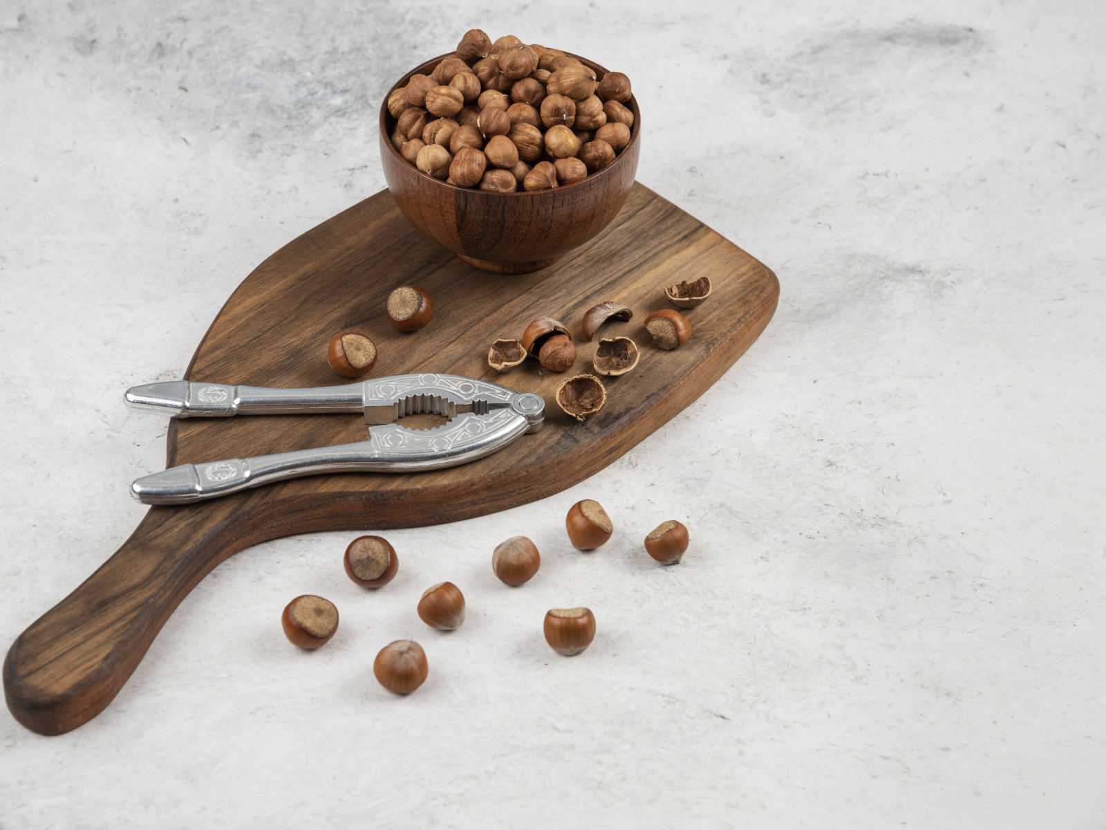 Лесные орехи на сером столе с разделочной доской