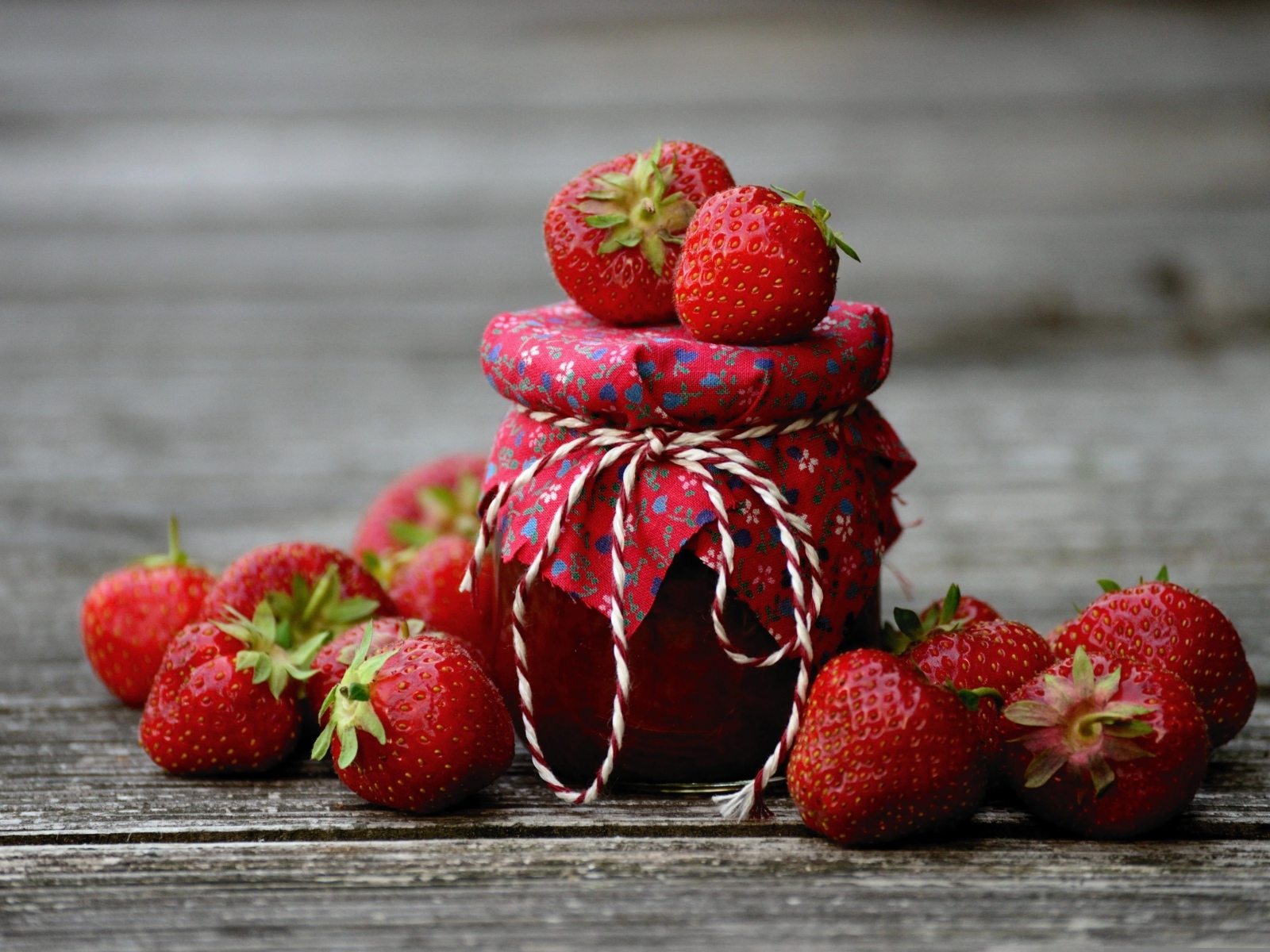 Банка джема на столе со свежими ароматными ягодами клубники