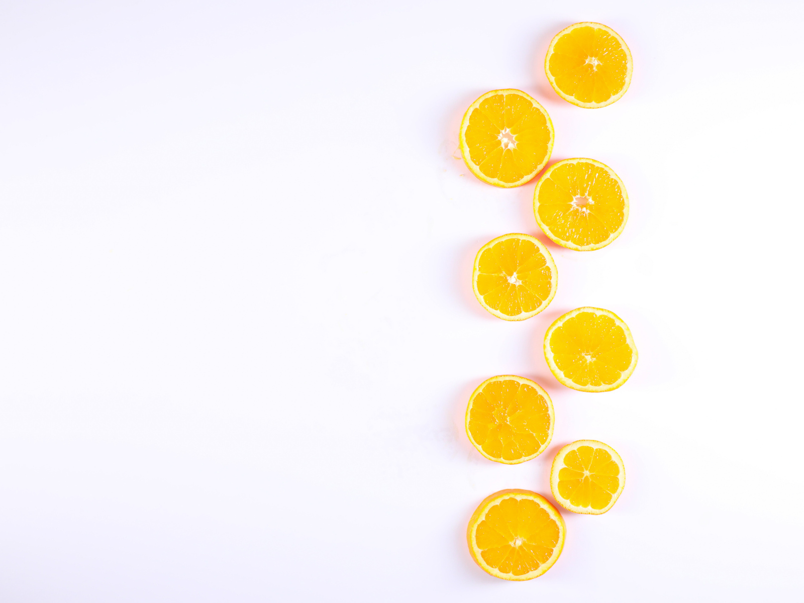 Много половинок лимона и апельсина на белом фоне