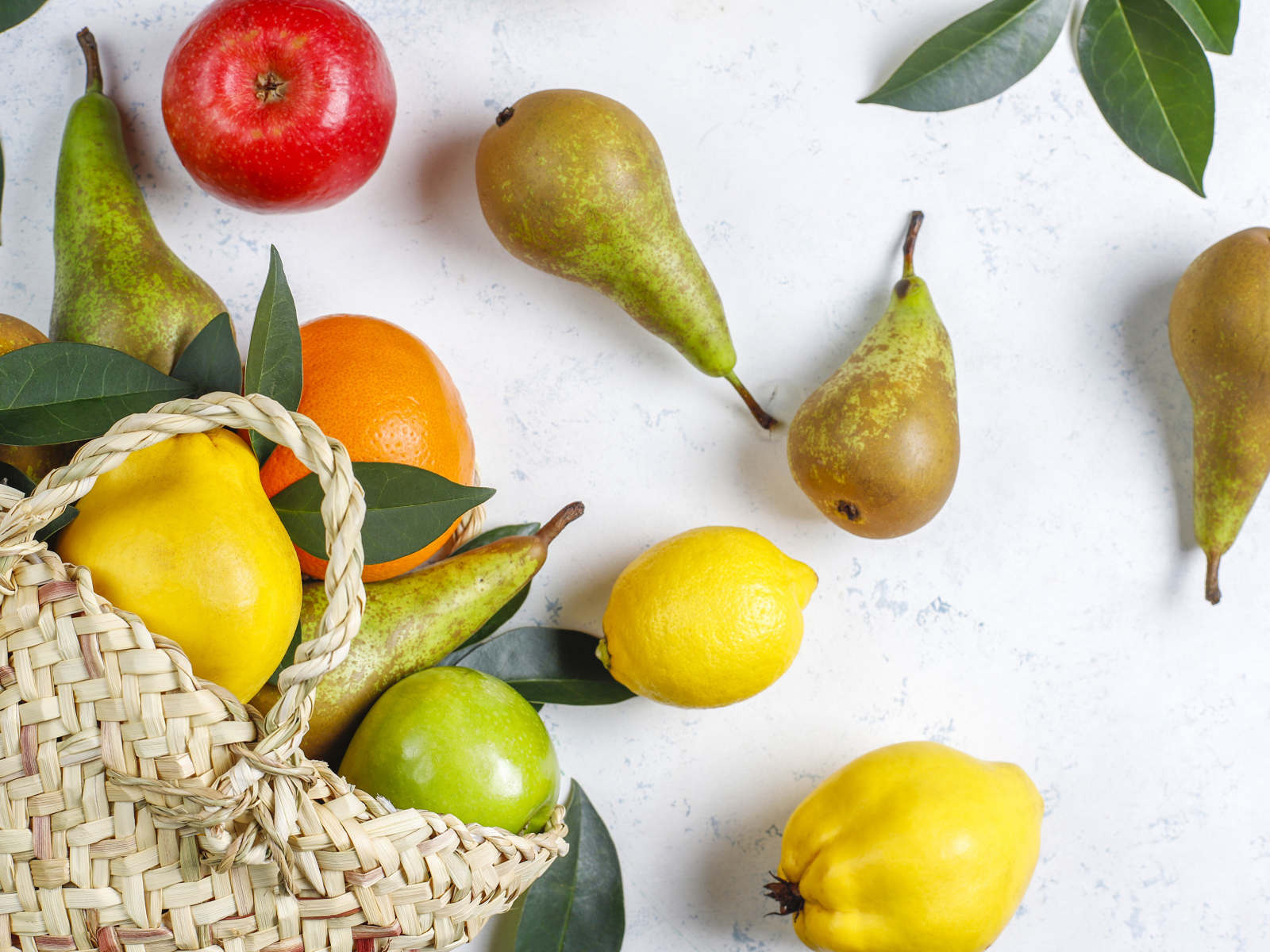 Груши, яблоки и апельсины с сумкой на столе