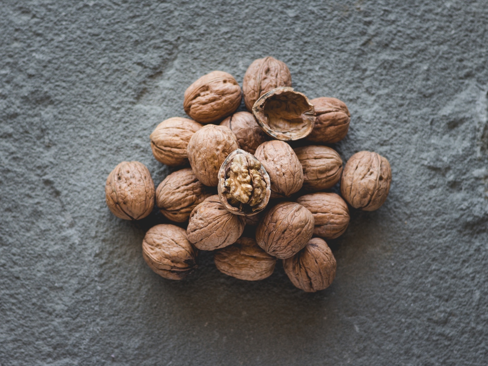 Куча грецких орехов на сером столе
