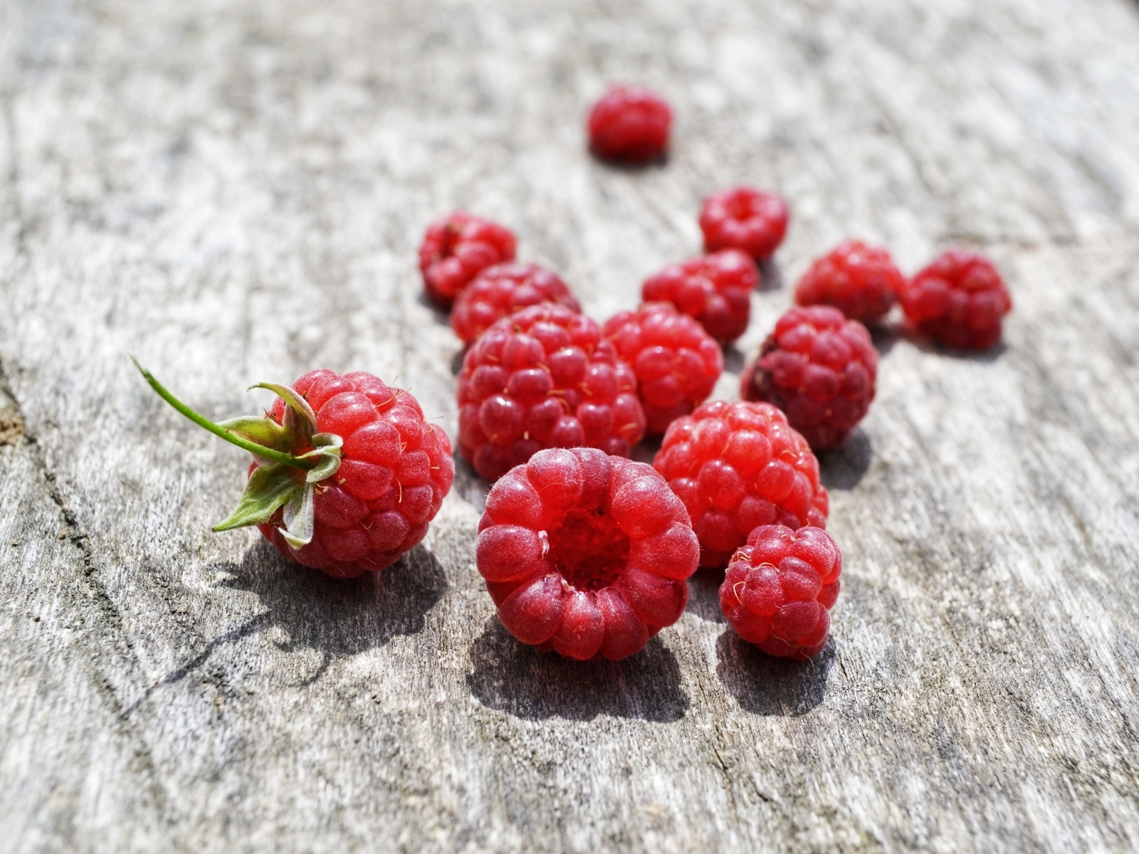 Красные ягоды малины на деревянном столе