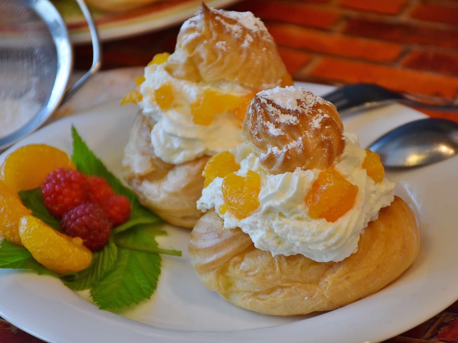 Заварное печенье со взбитыми сливками на тарелке с ягодами