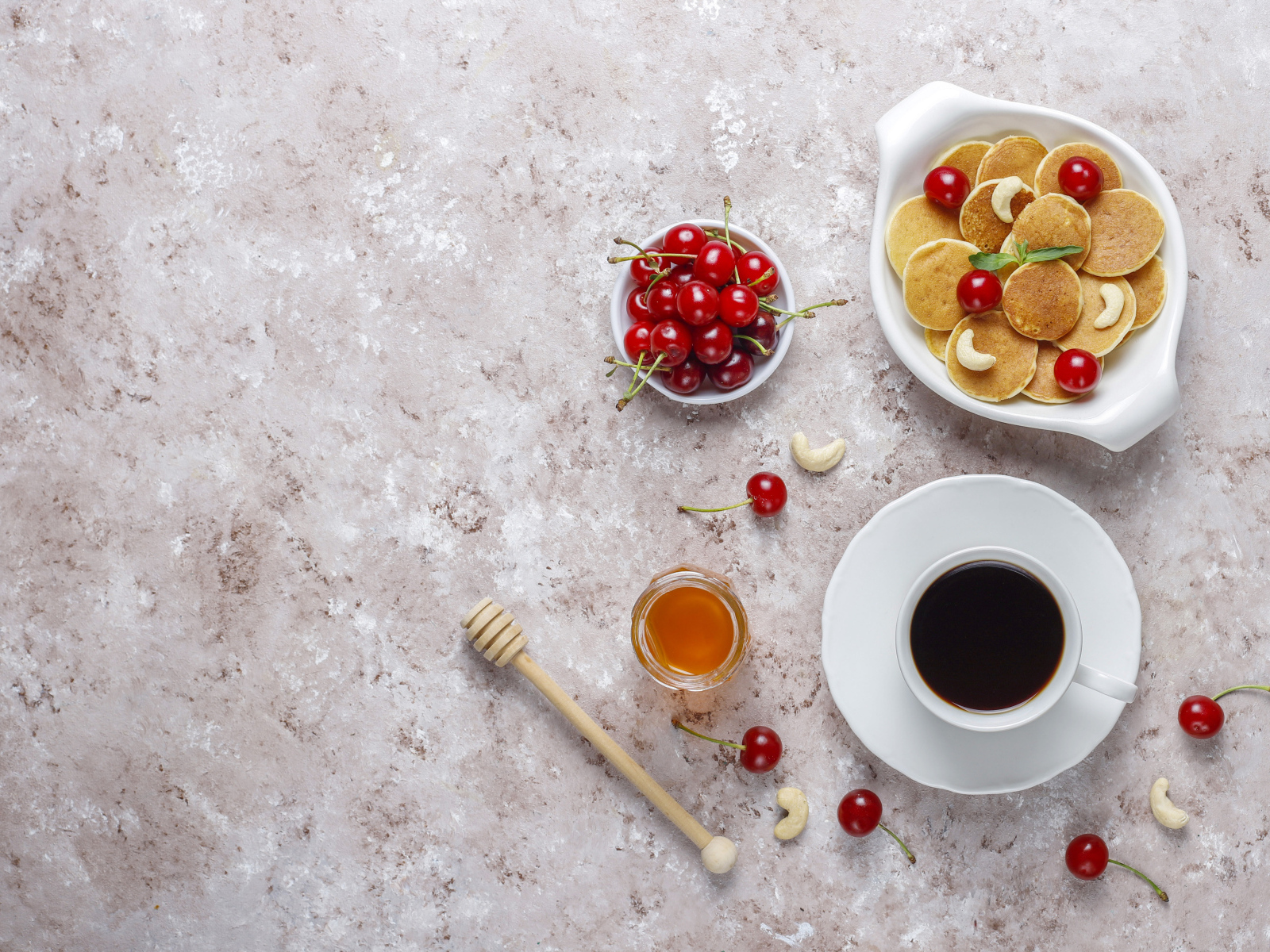 Оладьи на столе с вишней, кофе и медом