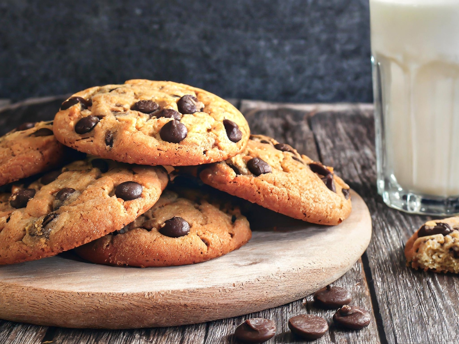 Круглое печенье с шоколадом на столе со стаканом молока