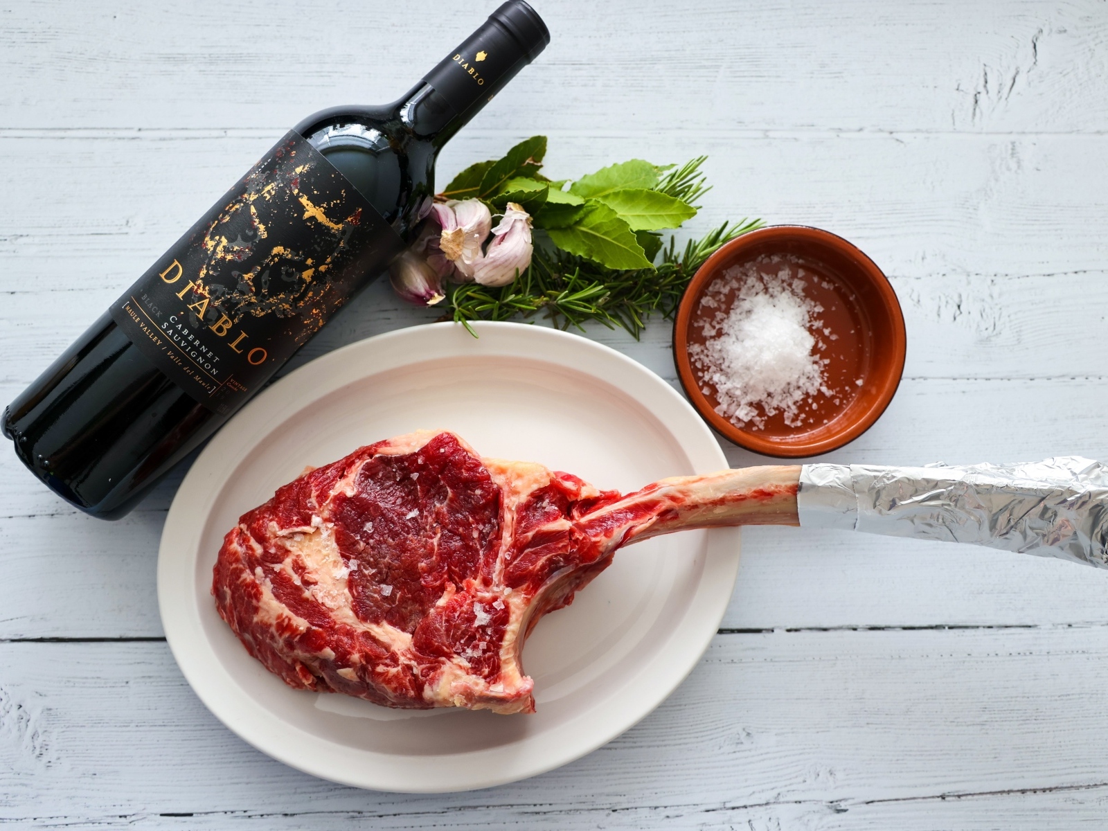 Стейк на кости с бутылкой вина