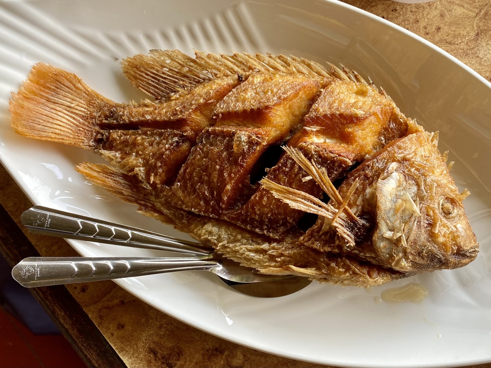 Запеченный карп на белой тарелке