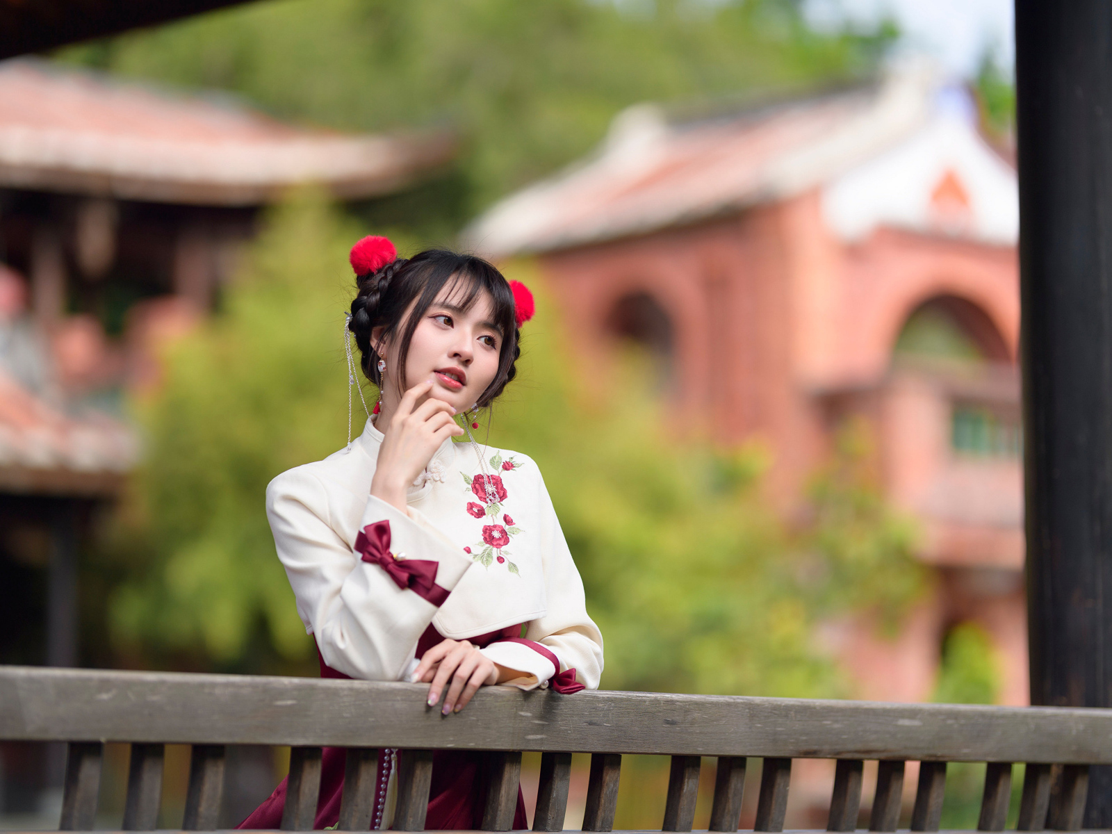 Девушка азиатка в народном костюме стоит у перил