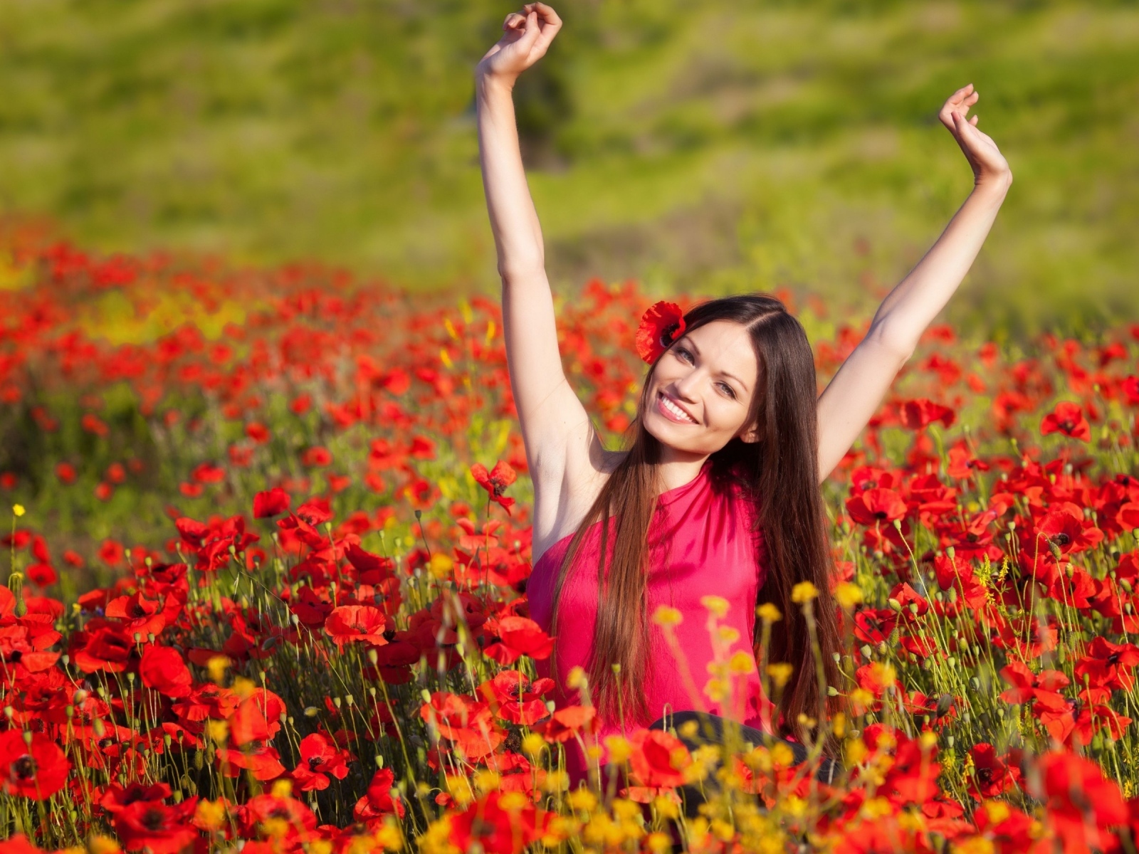 Красивая улыбающаяся девушка на поле с красными маками
