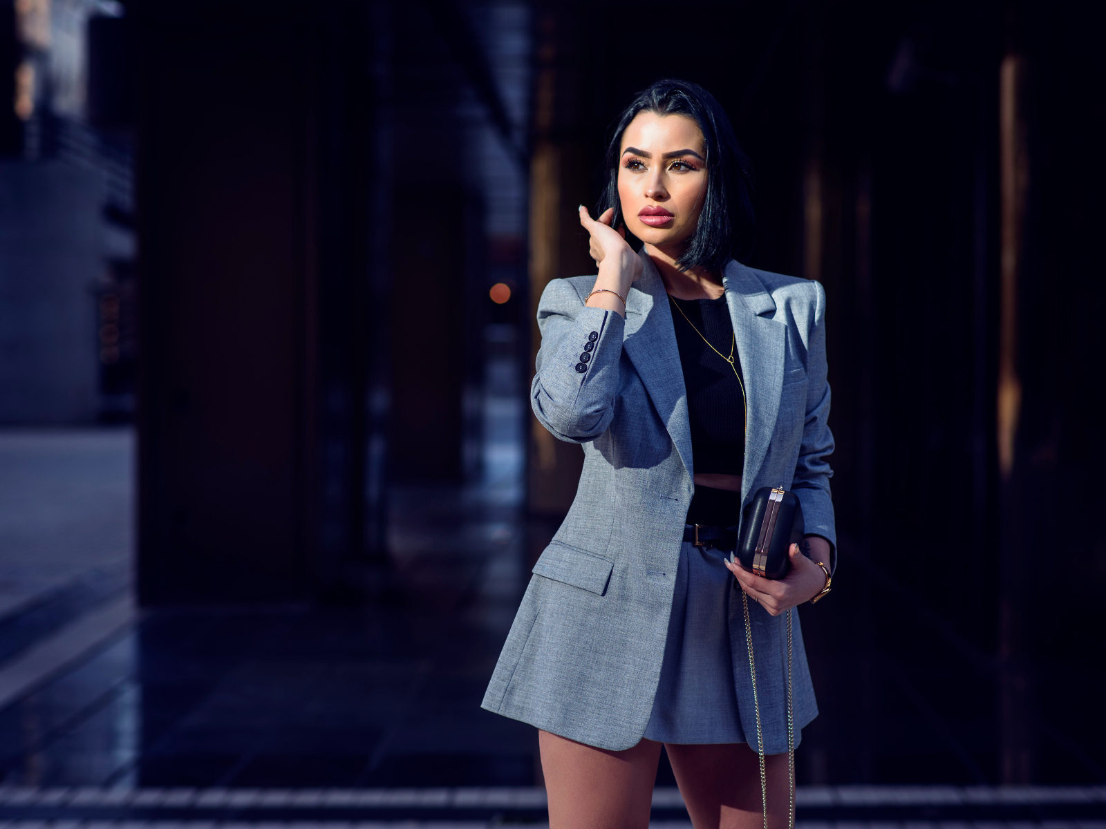 Деловая девушка в сером костюме с сумочкой