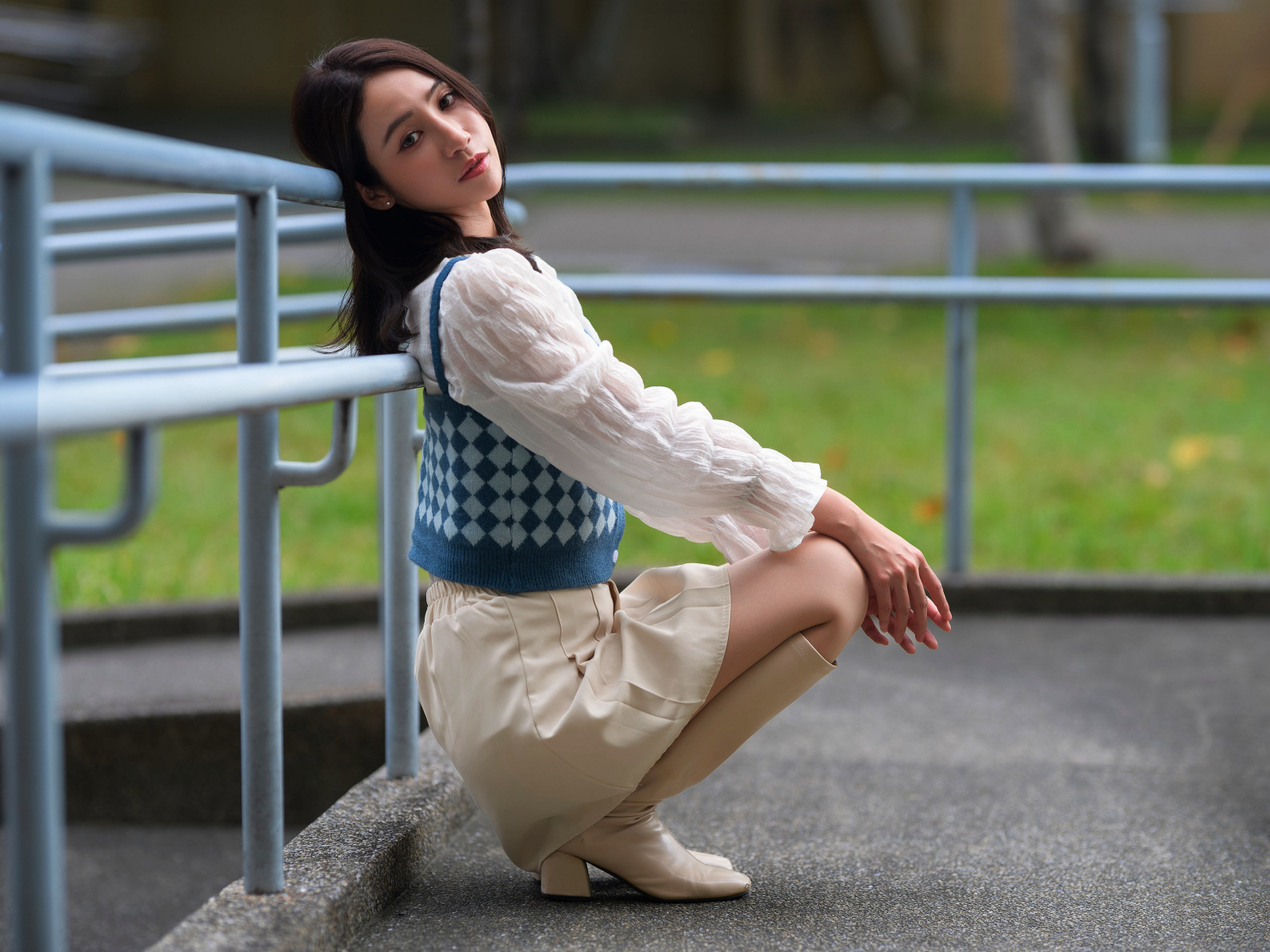 Милая девушка азиатка сидит у перил