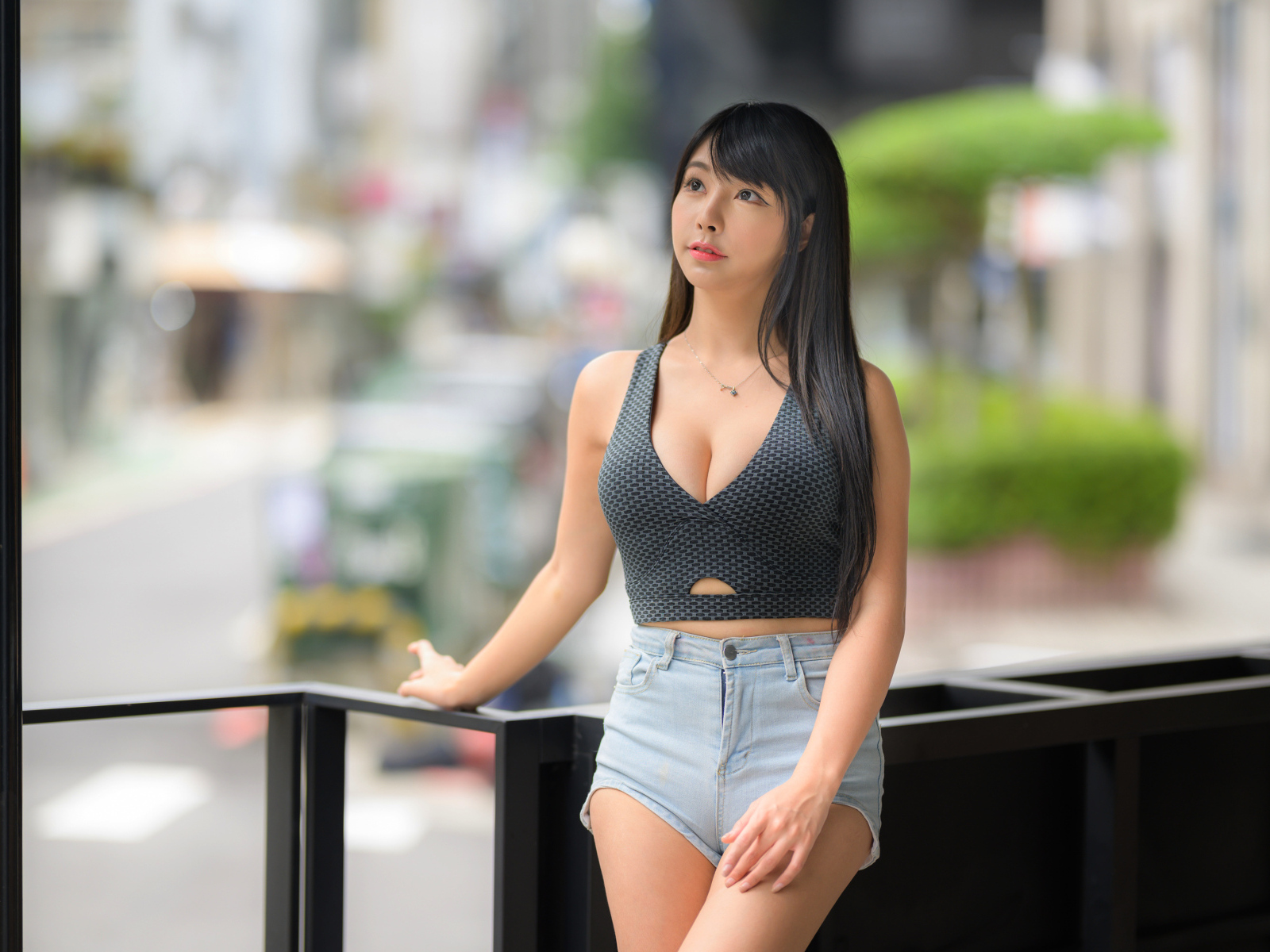 Мечтательная девушка азиатка в коротких шортах