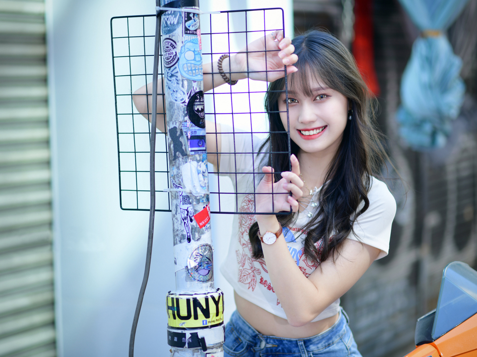 Улыбающаяся азиатка держится за сетку