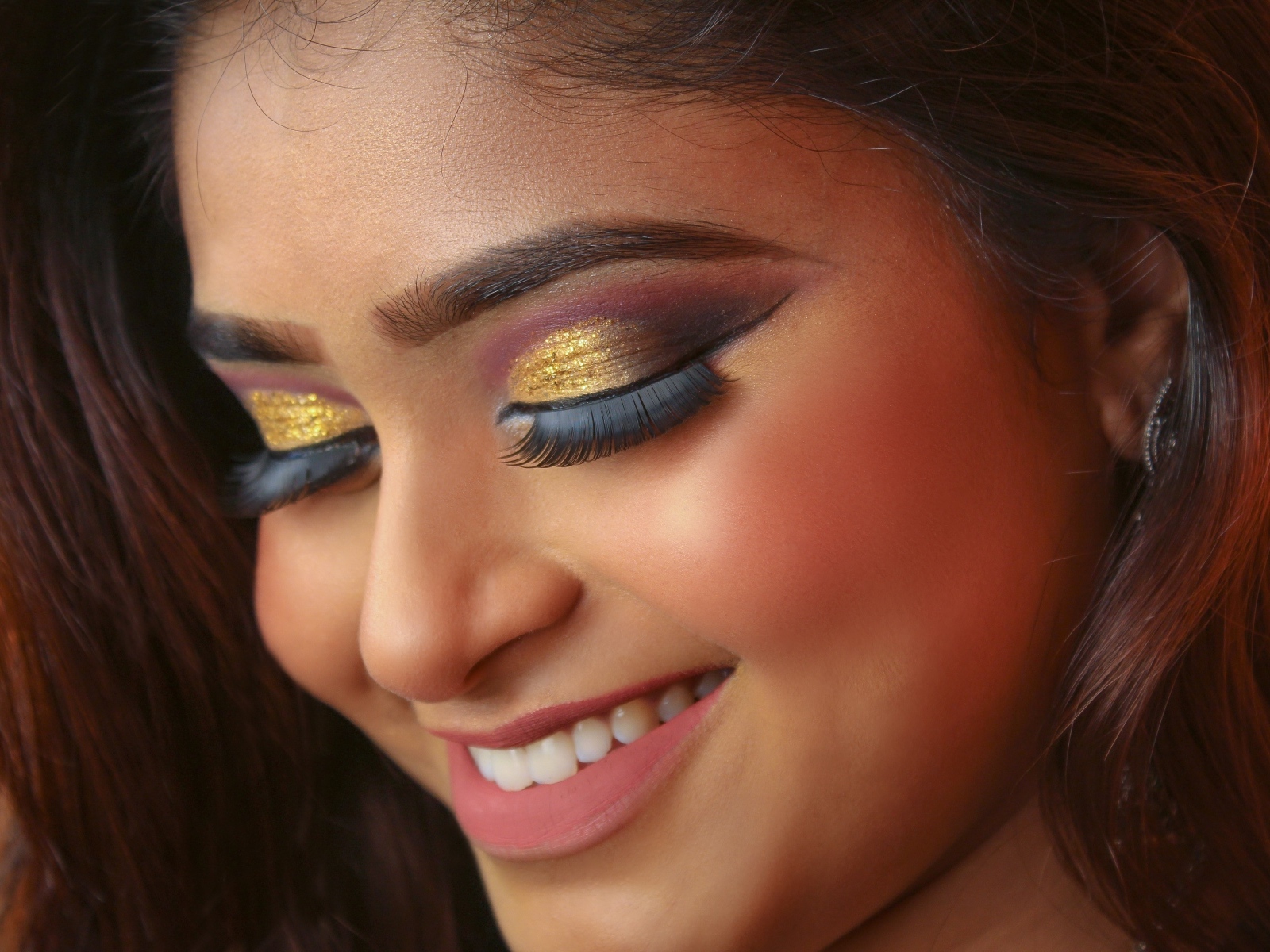 Улыбающаяся девушка с макияжем на глазах