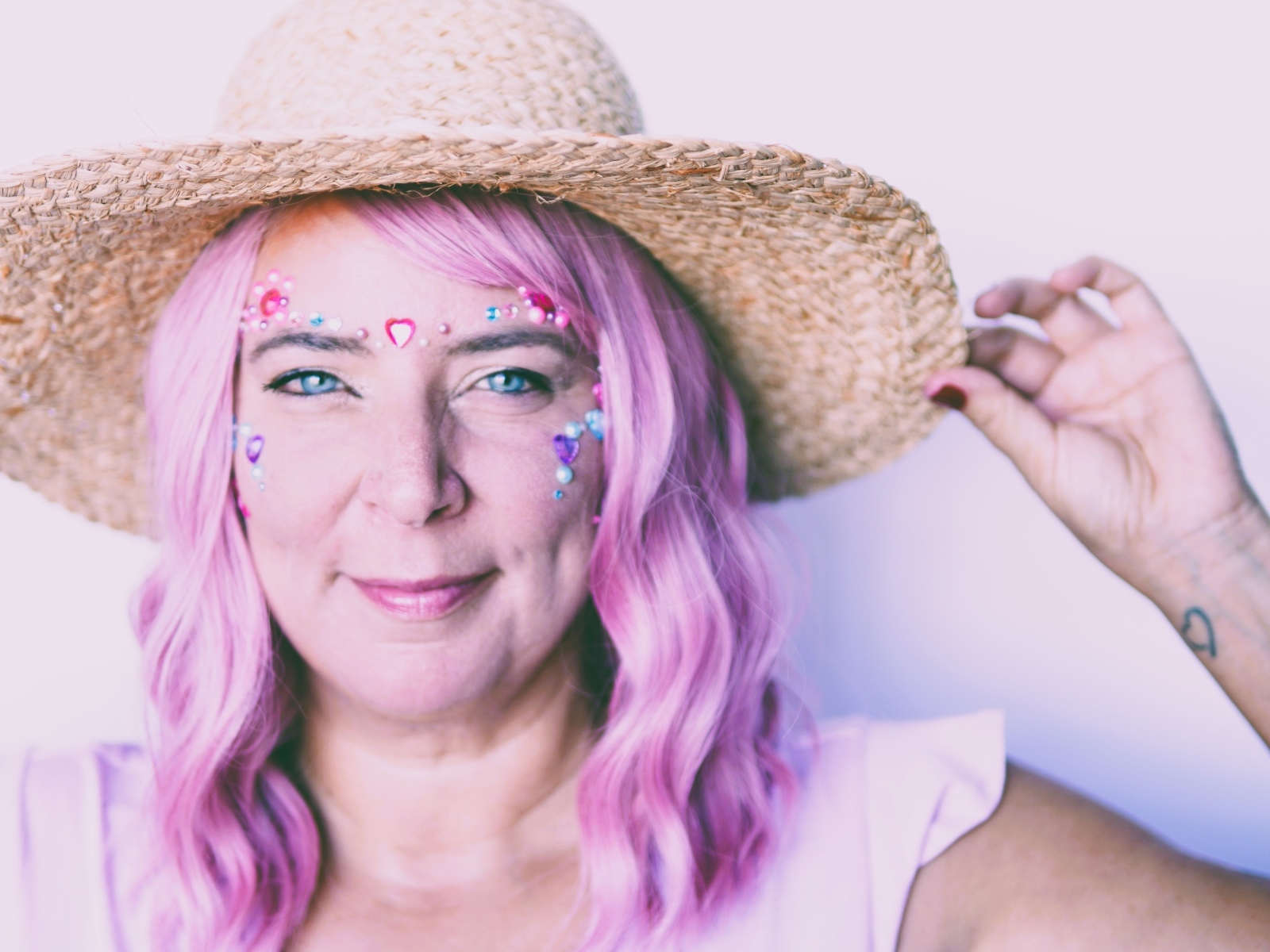 Женщина в шляпе с розовыми волосами