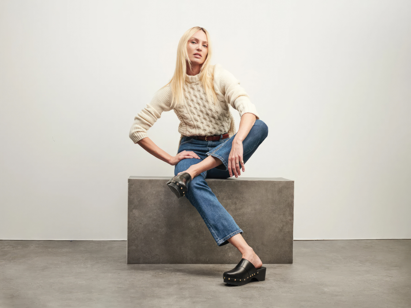 Модель Кэндис Свейнпол сидит на фоне серой стены