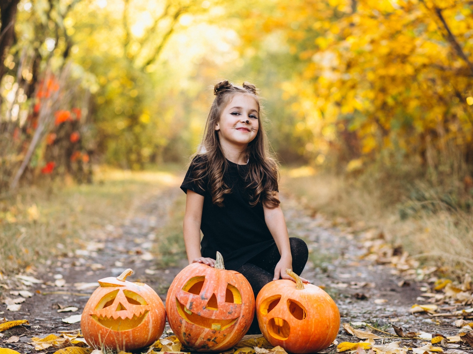 Девочка с тыквой в парке на праздник Хэллоуин
