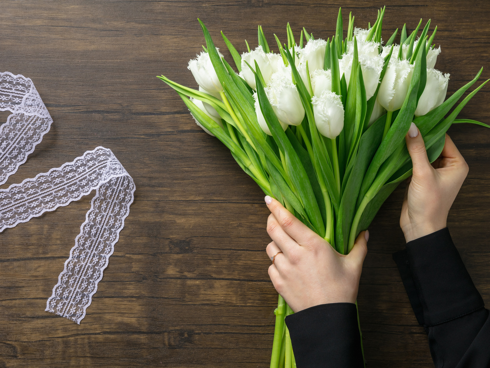 Большой букет белых тюльпанов с лентой на столе на 8 марта