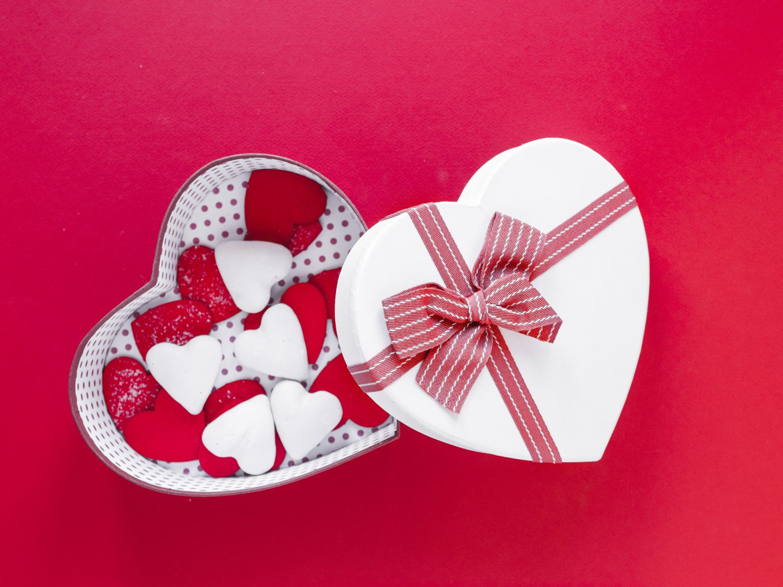Красивая коробка наполнена сердечками на красном фоне