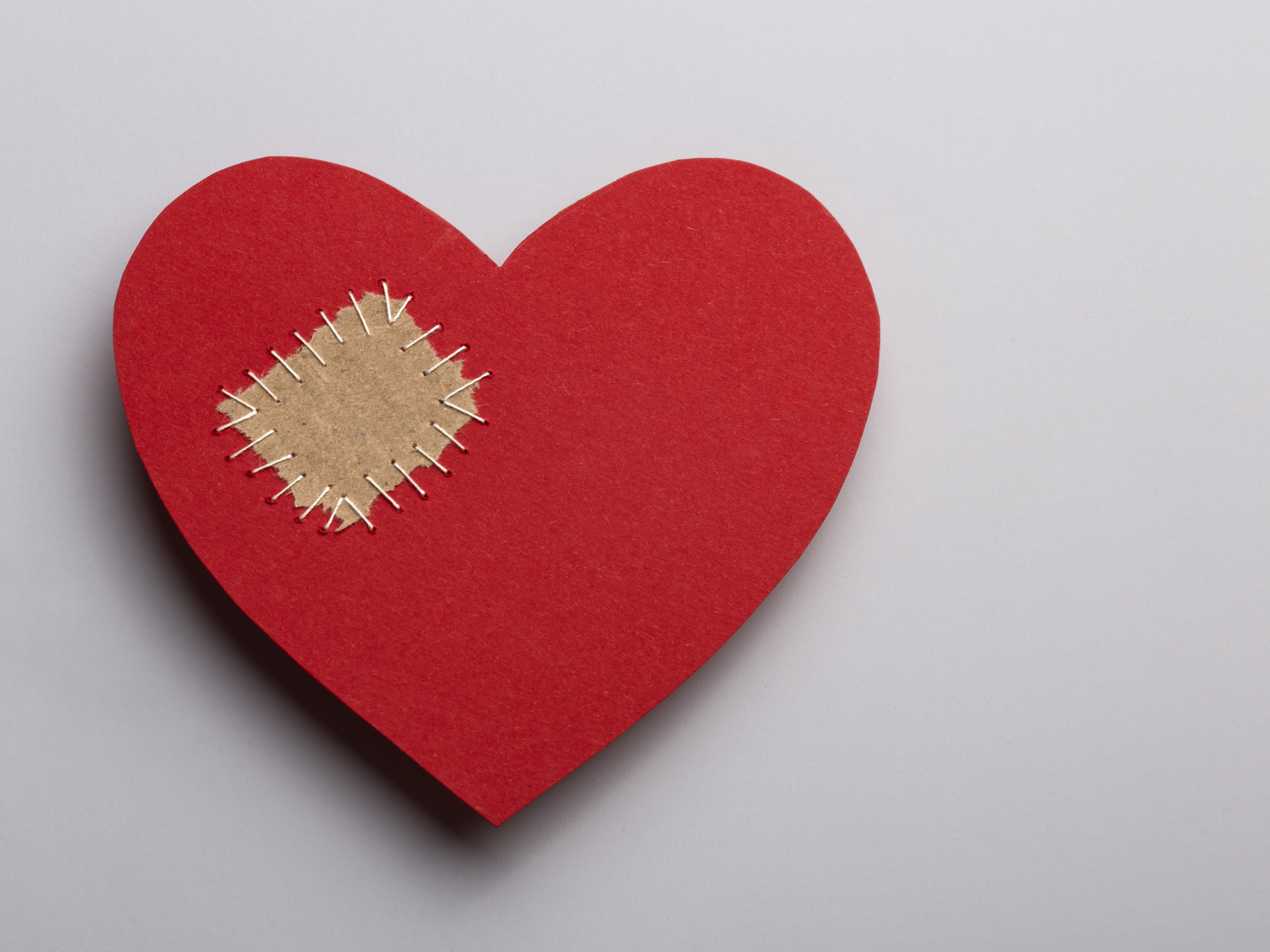 Большое красное сердце с заплаткой на сером фоне