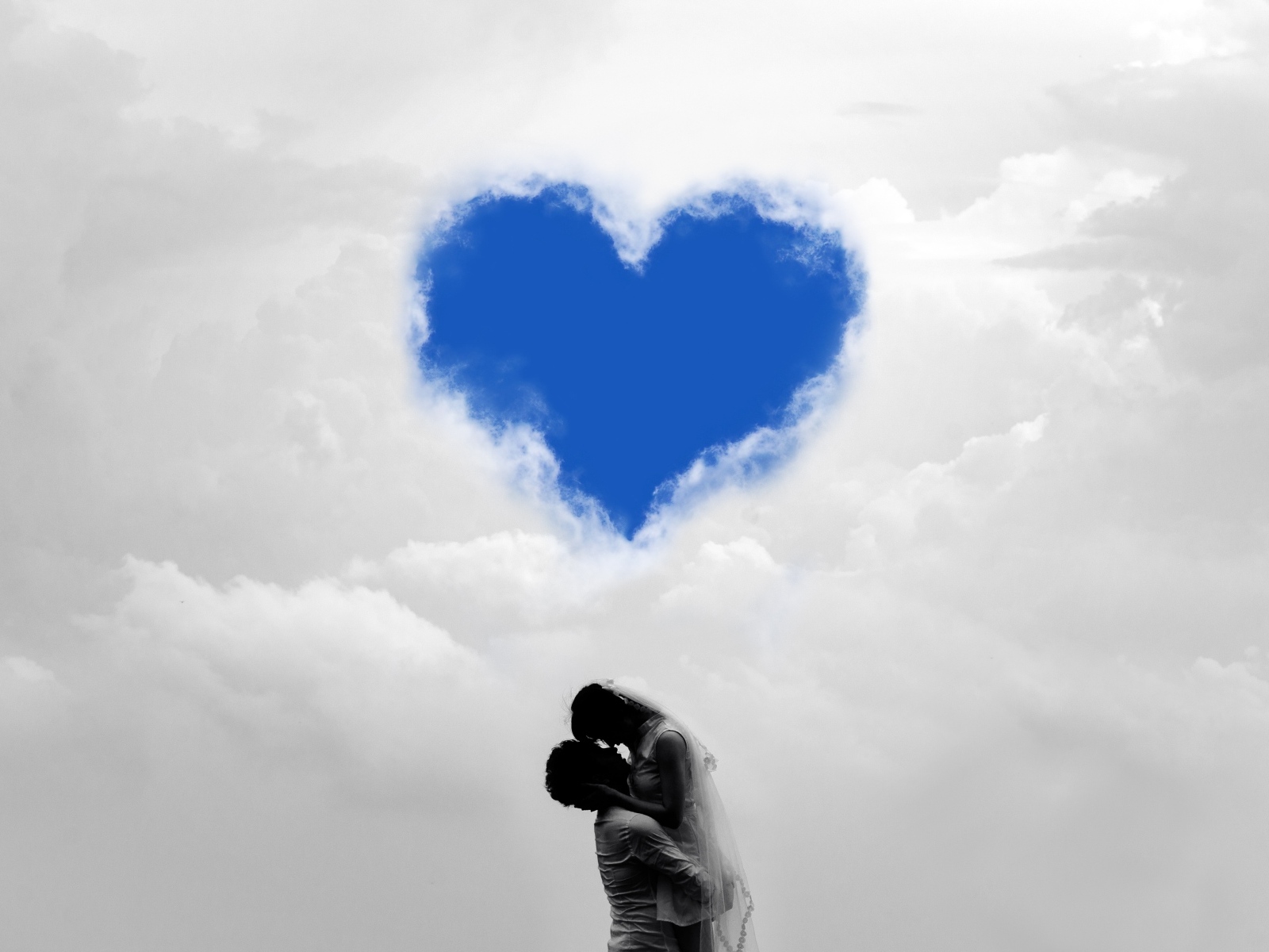 Пара на фоне сердца в небе в белых облаках