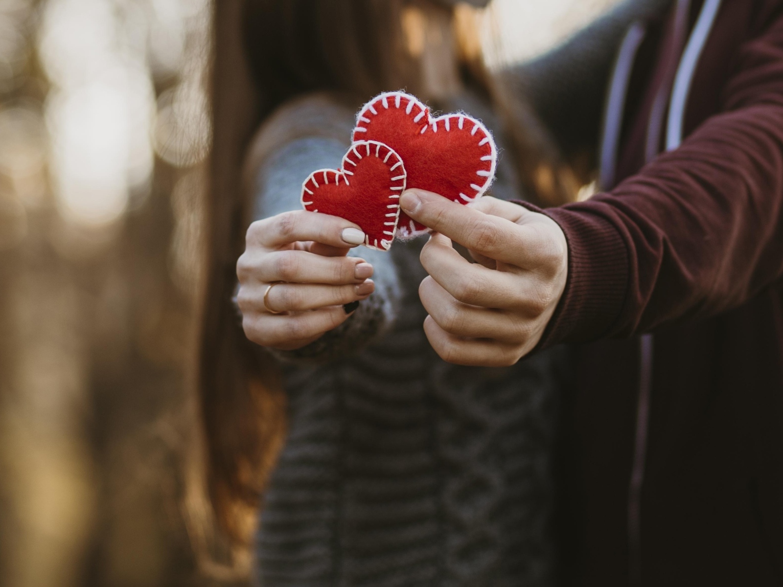 Влюбленная пара держит сердечки в руках
