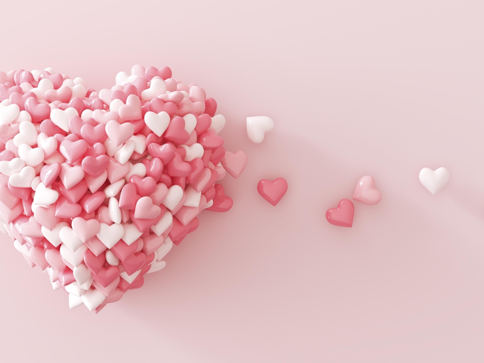 Сердце из маленьких сердечек на розовом фоне
