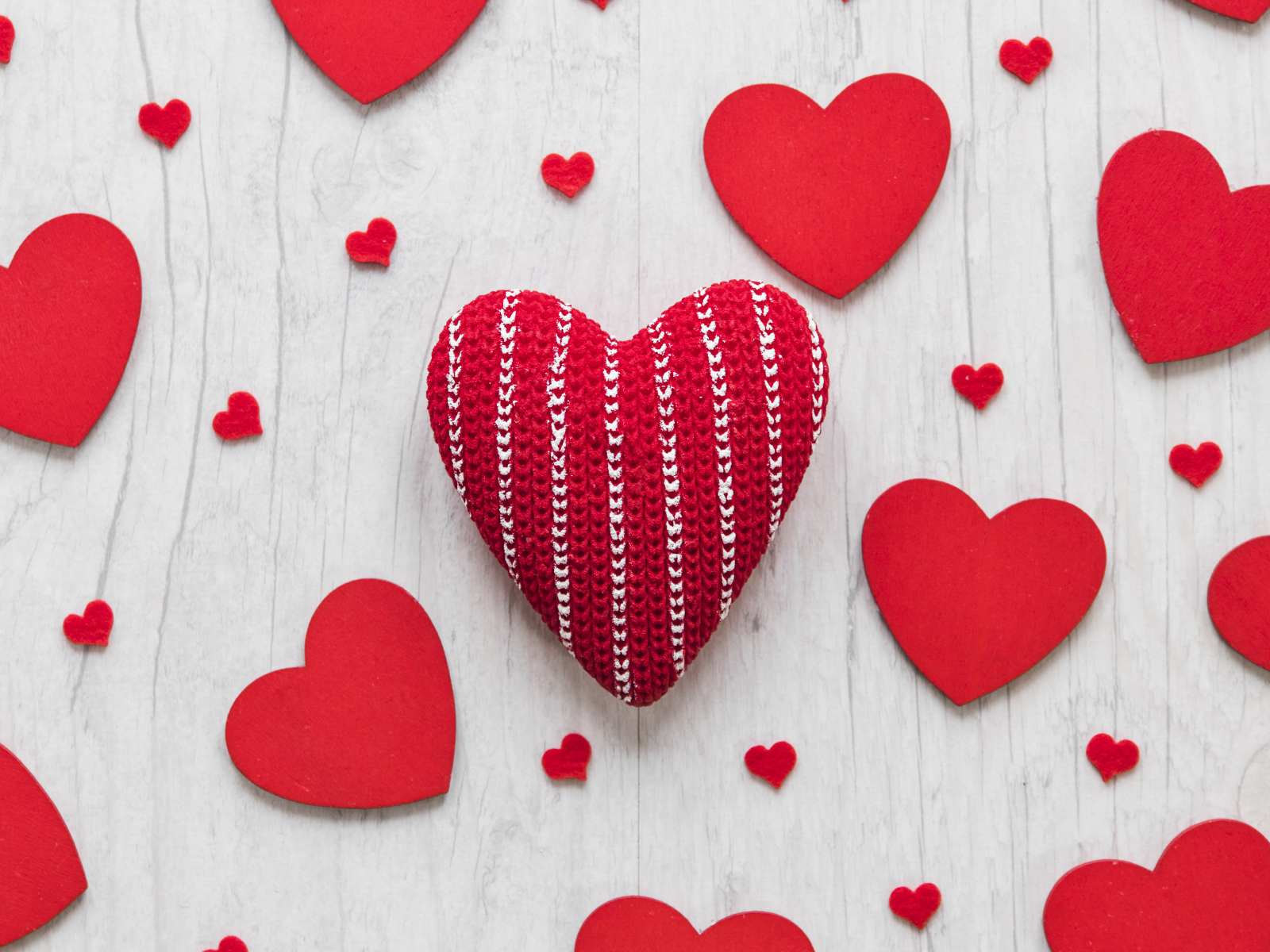 Много красных сердец на белом деревянном столе