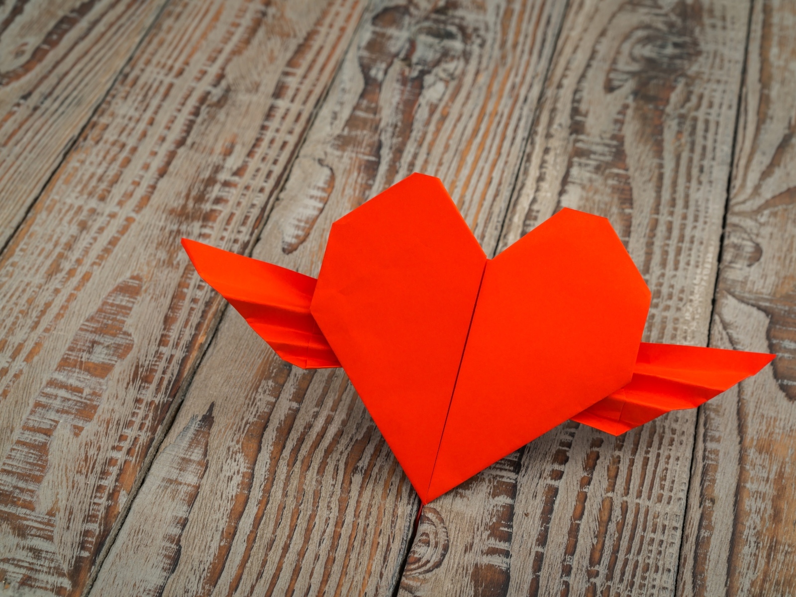 Бумажное красное сердце на деревянных досках