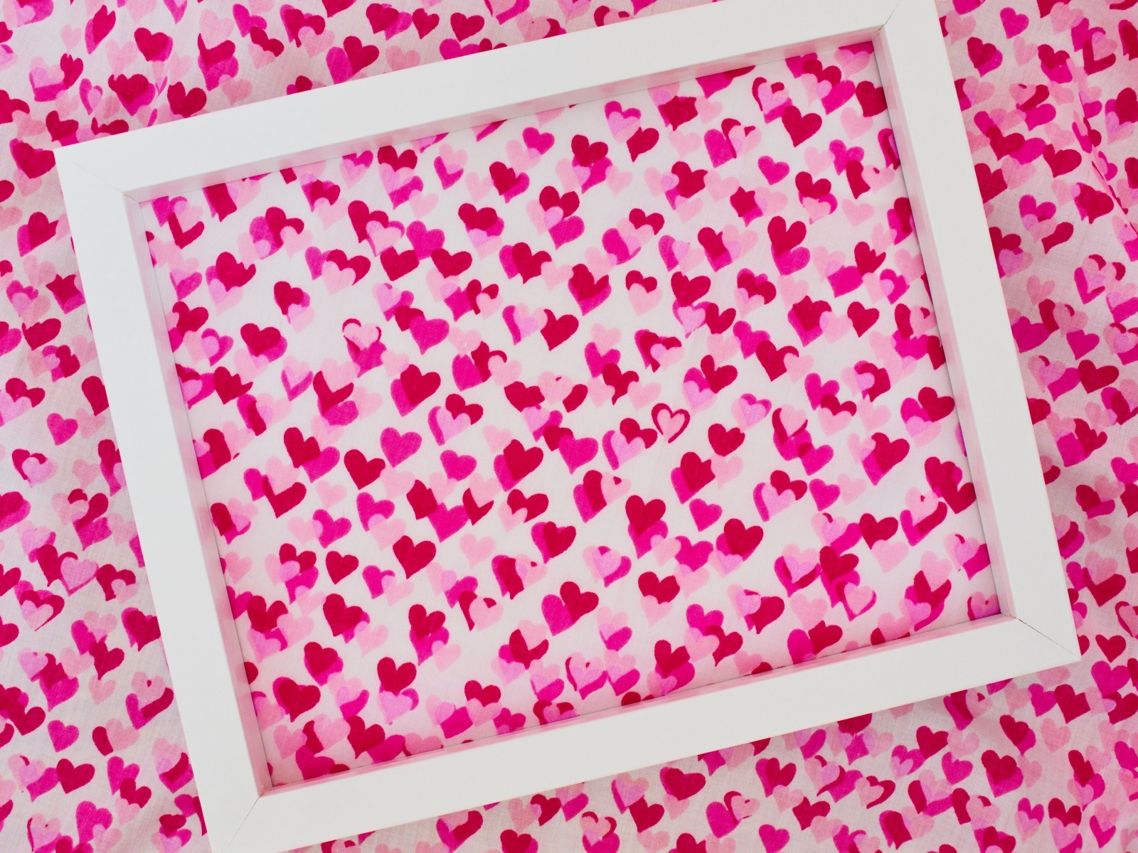 Белая рамка на ткани с маленькими сердечками
