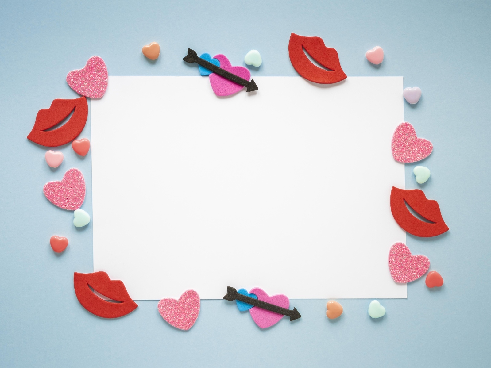 Белый лист бумаги с сердечками и губами на голубом фоне, шаблон открытки