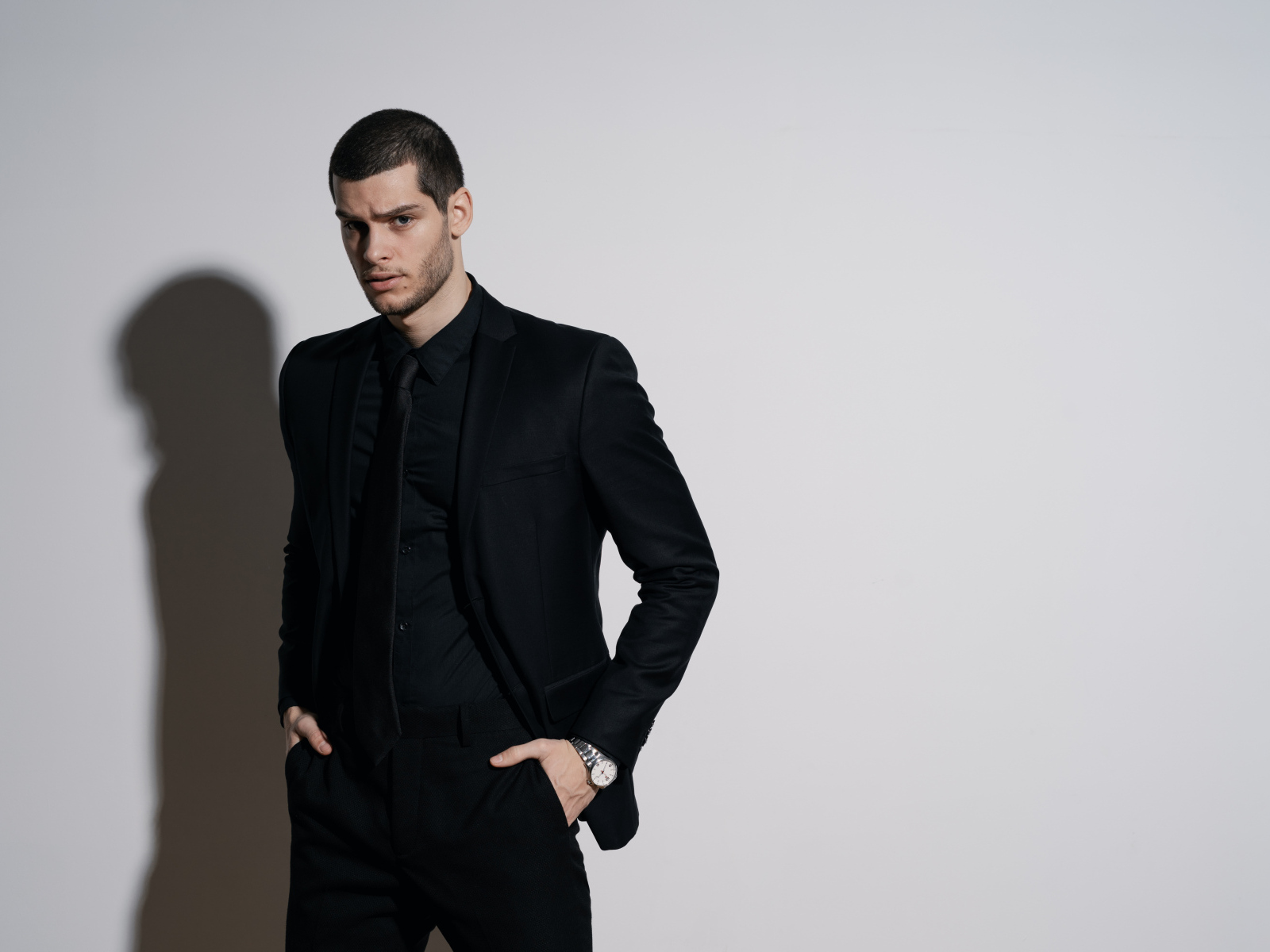 Красивый деловой мужчина стоит у серой стены