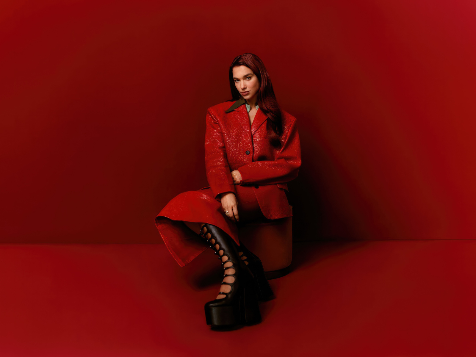 Британская певица Дуа Липа на красном фоне