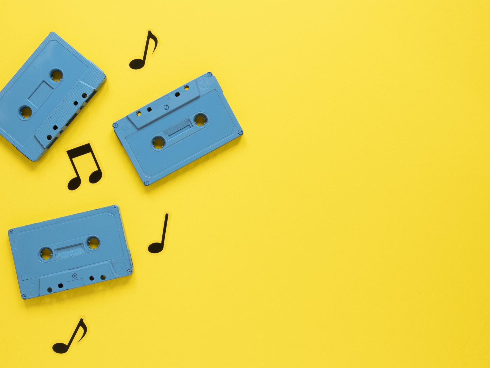 Три голубые кассеты с нотами на желтом фоне