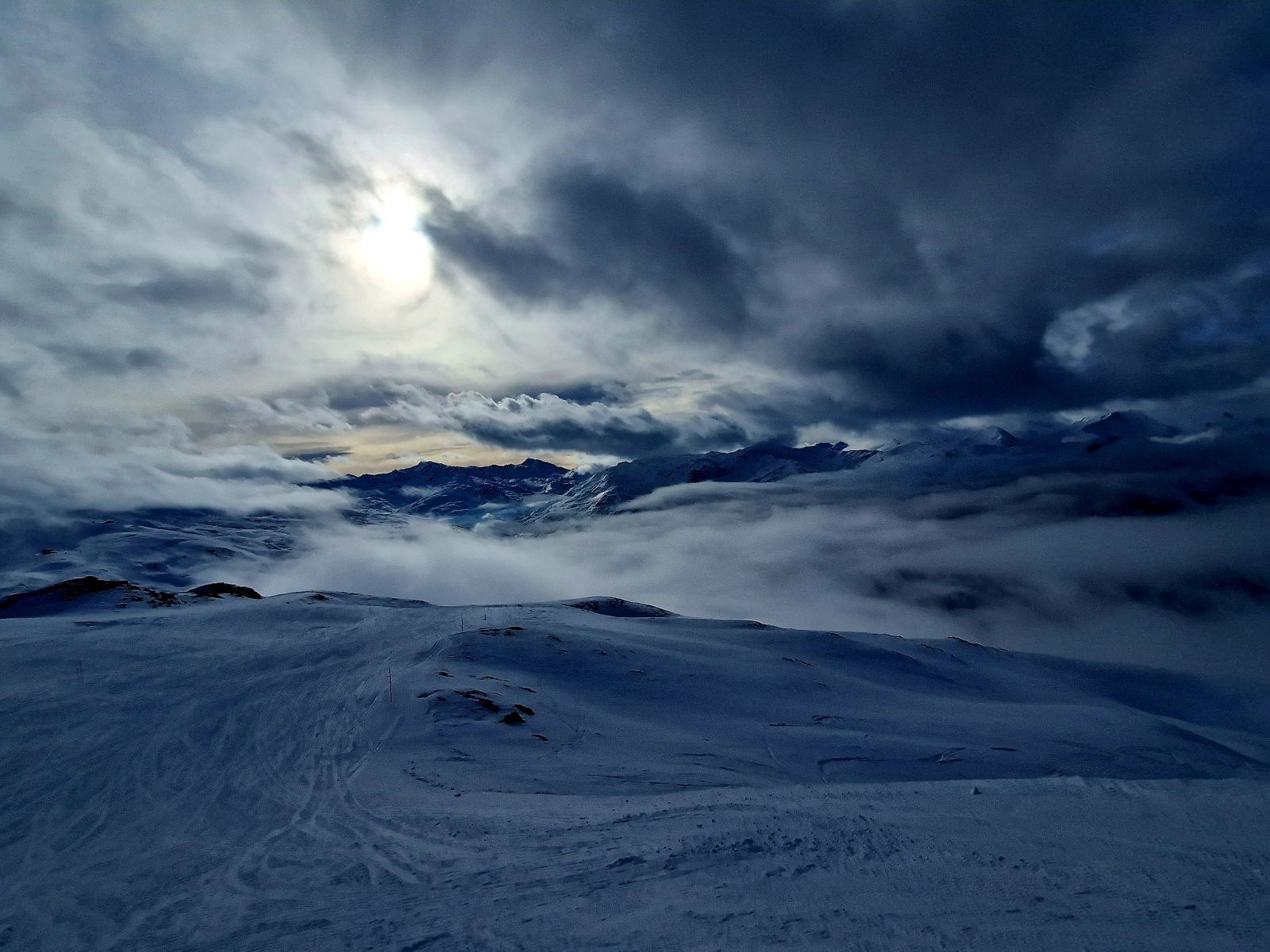 Луна в облачном небе над заснеженными горами