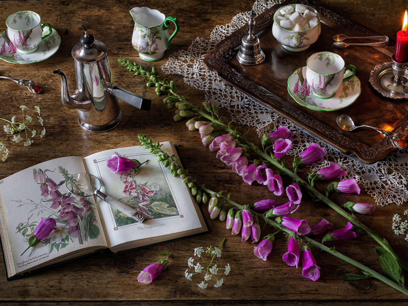 Розовые цветы на столе с книгой и чаем