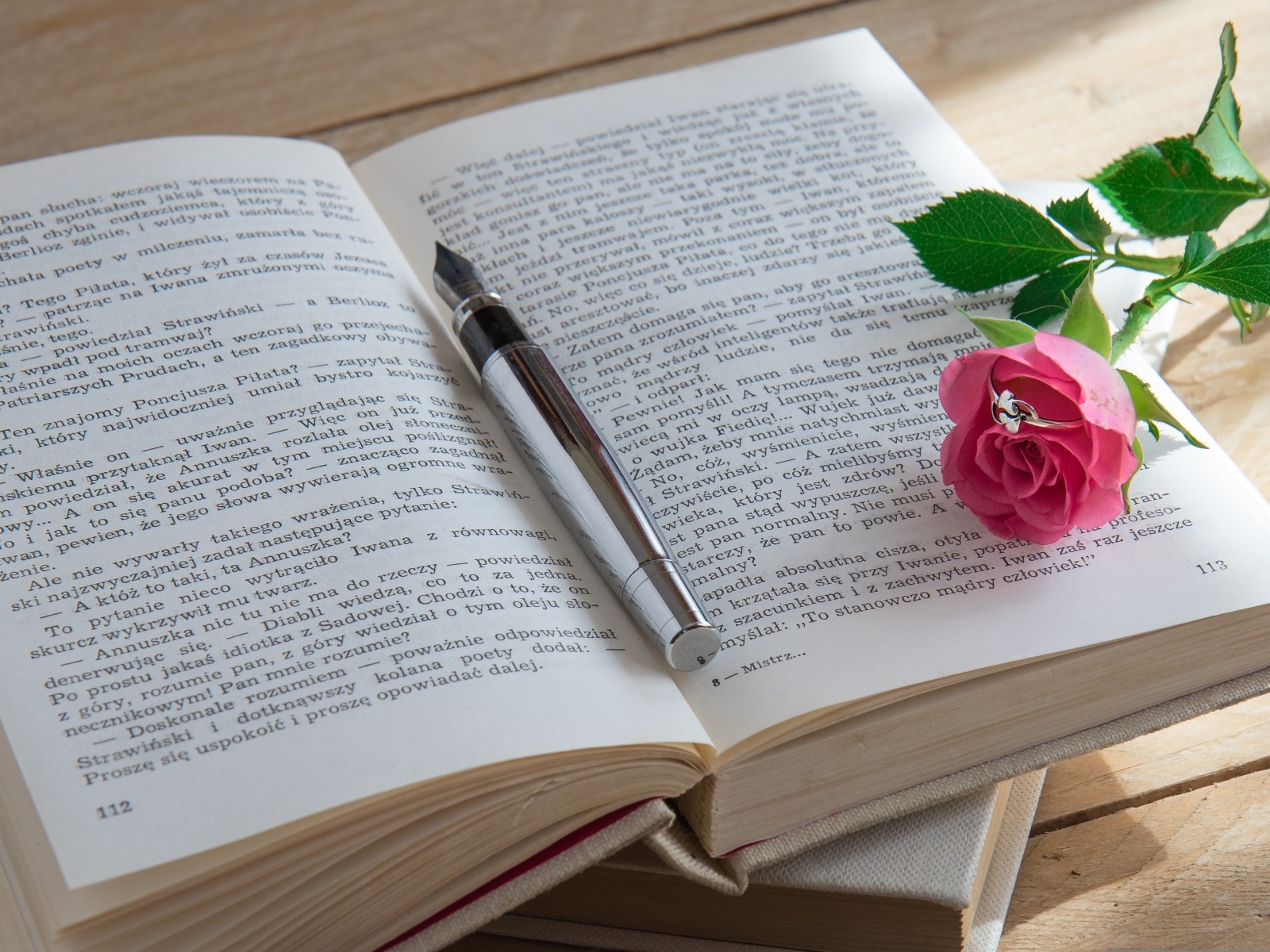 Розовая роза с кольцом на книге 