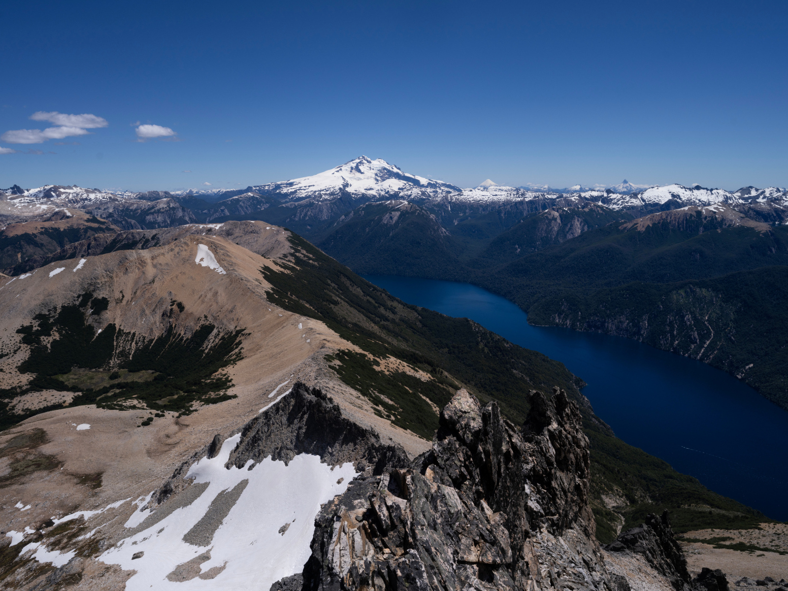 Высокие заснеженные горы и река под голубым небом