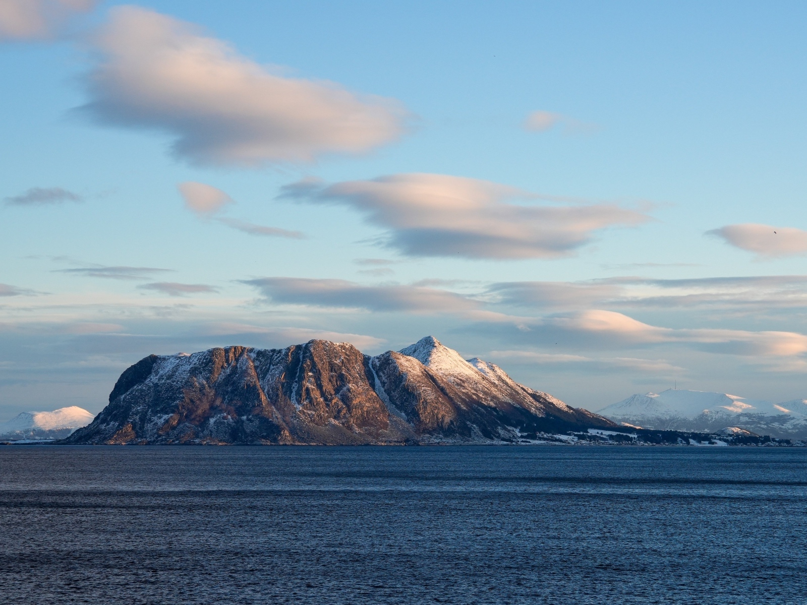 Скала в лучах солнца в море