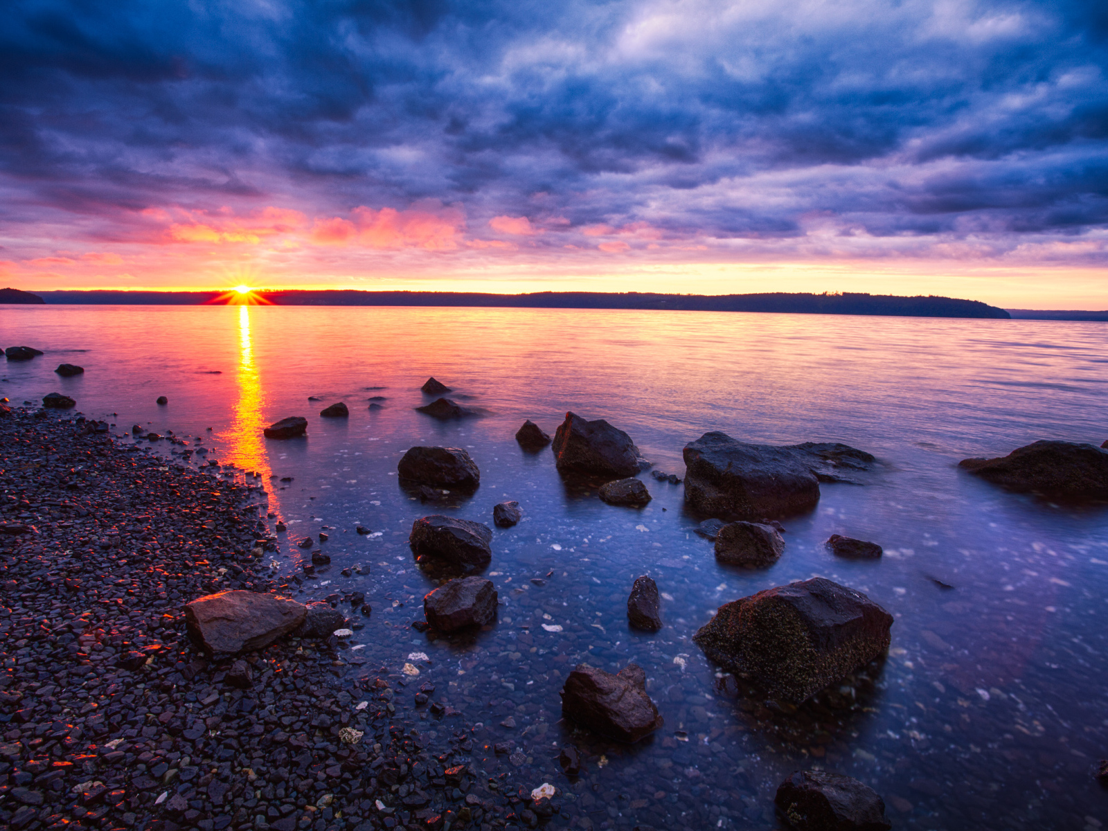 Закат солнца в пасмурном небе у озера