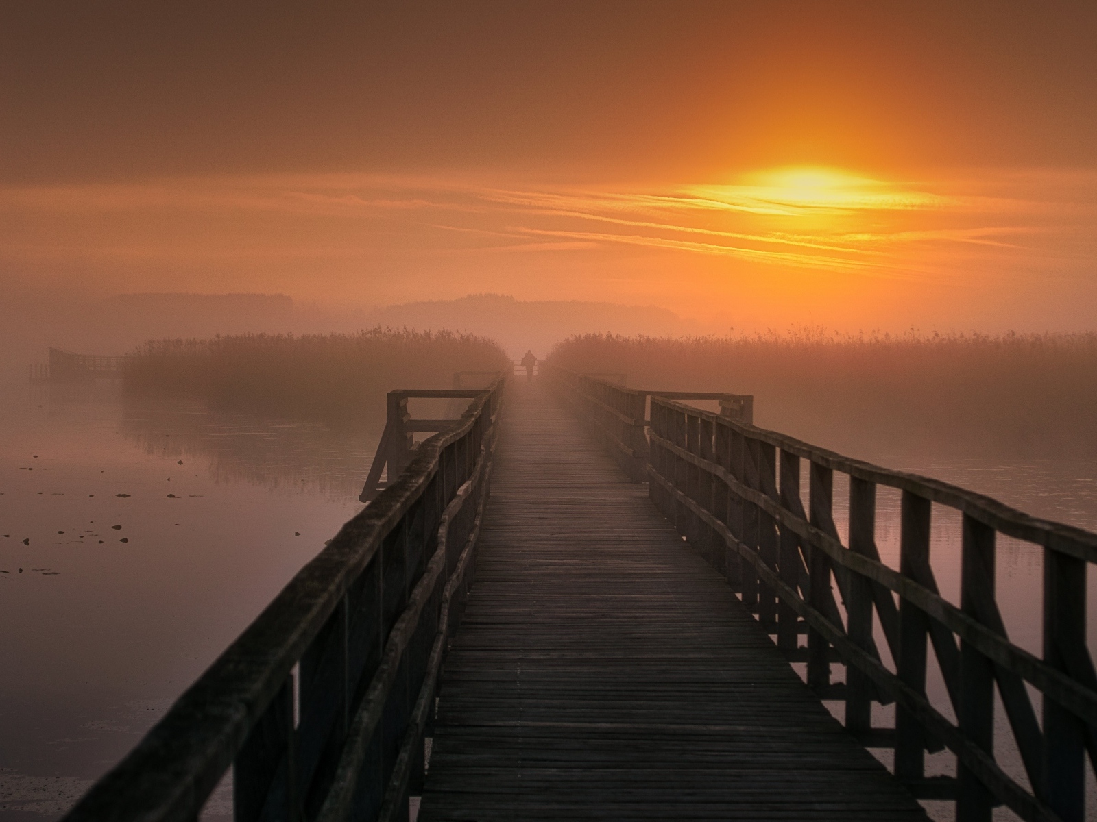 Деревянный мост над рекой на закате