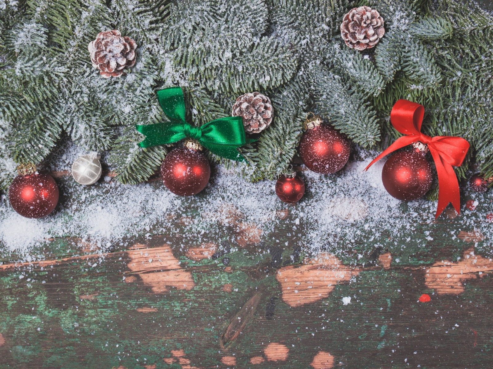 Зеленые заснеженные еловые ветки с красными шариками