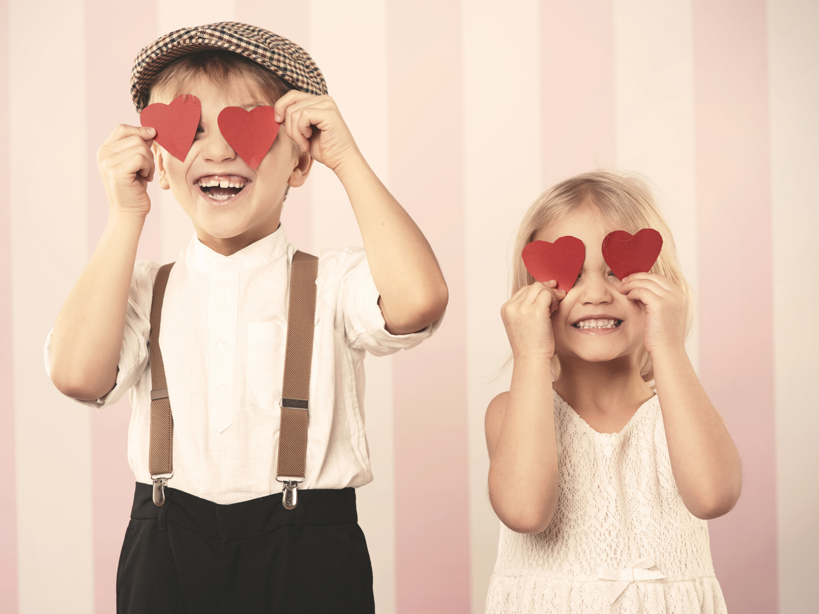 Мальчик и девочка с сердечками в руках