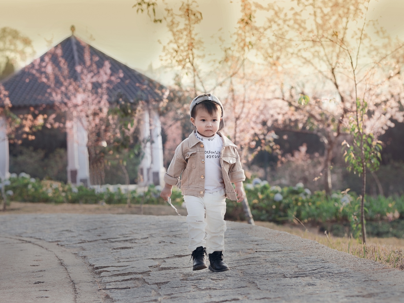 Милый мальчик гуляет по дороге у дома